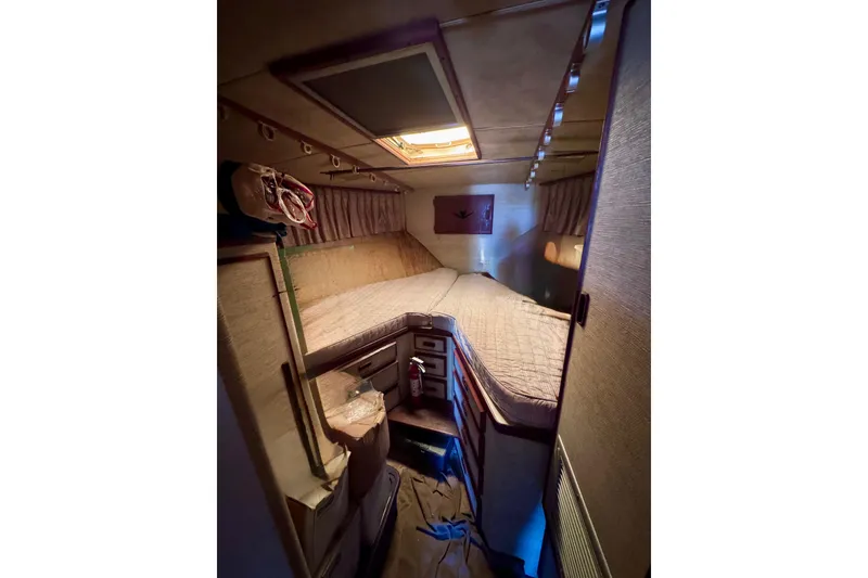Slide: The Image of Cozy cabin interior of 1986 Bertram 46III Convertible yacht with bed and storage. - 60