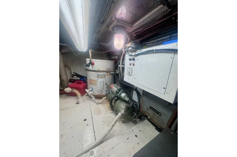Slide: The Image of Engine room of a 1986 Bertram 46III Convertible boat, featuring machinery and control panels. - 69