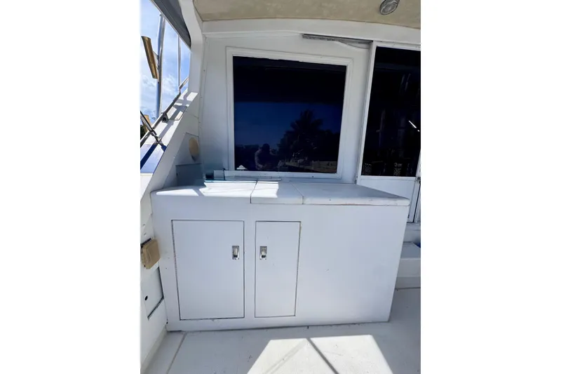Slide: The Image of 1986 Bertram 46III Convertible yacht interior with white cabinetry and window reflection. - 10