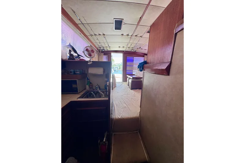 Slide: The Image of Interior of a 1986 Bertram 46III Convertible yacht, featuring a compact kitchen area. - 56