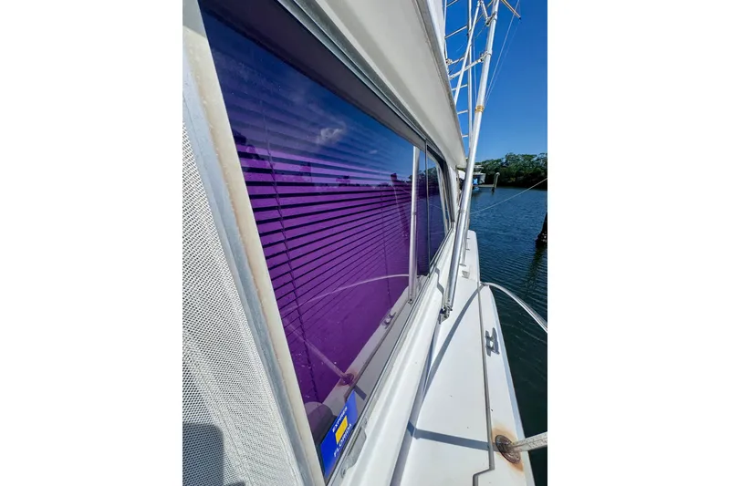 Slide: The Image of Side view of a 1986 Bertram 46III Convertible yacht with purple-tinted windows. - 47