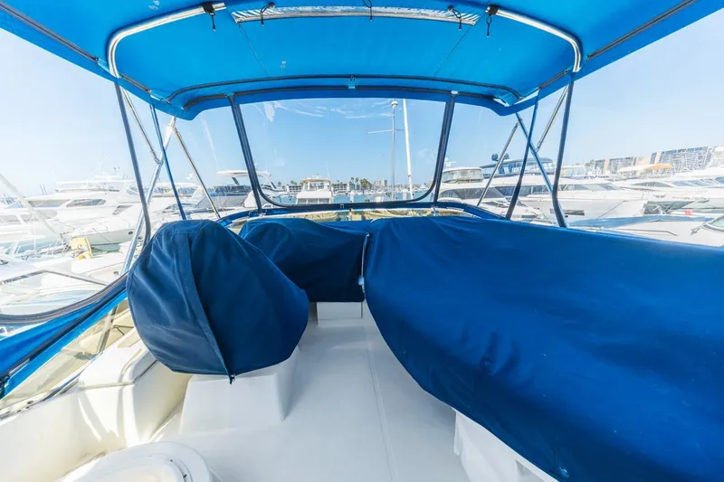 Slide: The Image of Interior view of 2006 Azimut 43 yacht with blue covers and marina background. - 12