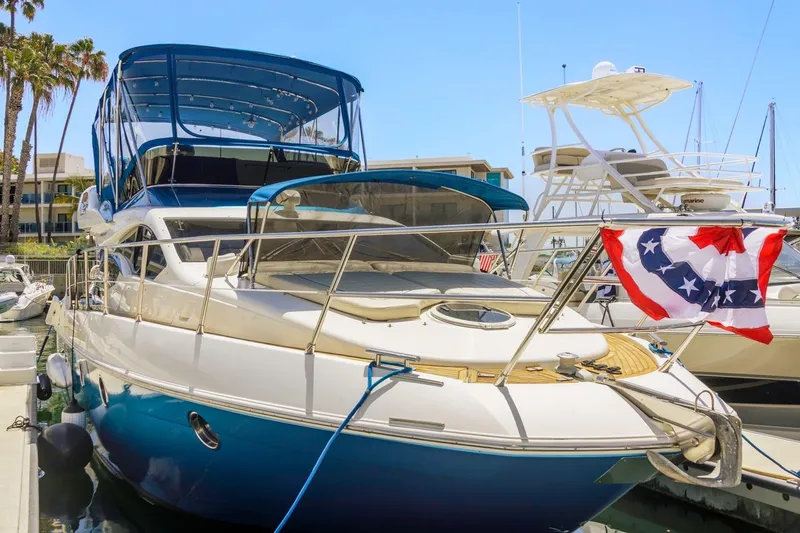 Slide: The Image of Luxury 2006 Azimut 43 yacht docked, featuring blue canopy and decorative flag. - 7