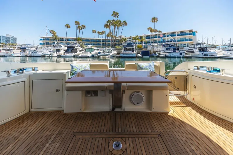 Slide: The Image of Luxury yacht Azimut 43, 2006 model, docked at marina with wooden deck and table. - 11