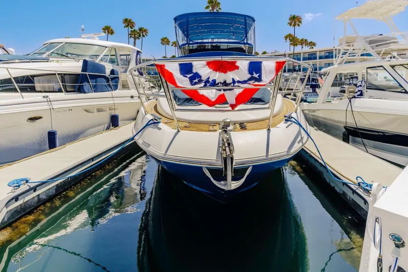 Slide: The Image of 2006 Azimut 43 yacht docked, adorned with festive red, white, and blue bunting. - 6