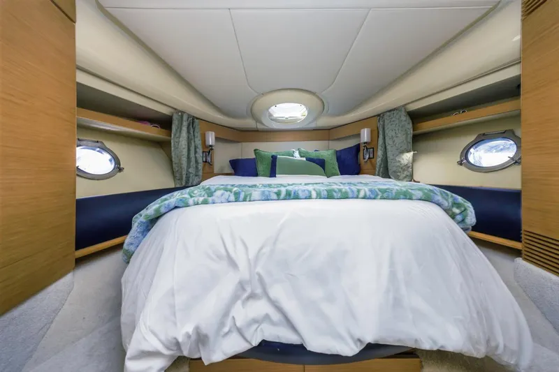 Slide: The Image of Luxurious bedroom interior of 2006 Azimut 43 yacht with elegant bedding and porthole windows. - 32