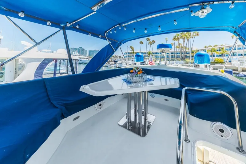 Slide: The Image of Luxurious 2006 Azimut 43 yacht deck with blue canopy and elegant seating area. - 13