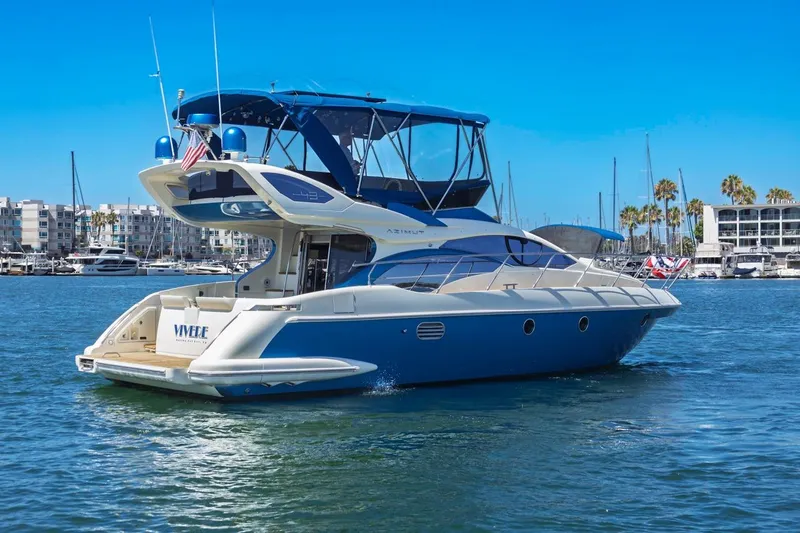 Slide: The Image of Luxury 2006 Azimut 43 yacht cruising in a marina under clear blue skies. - 4