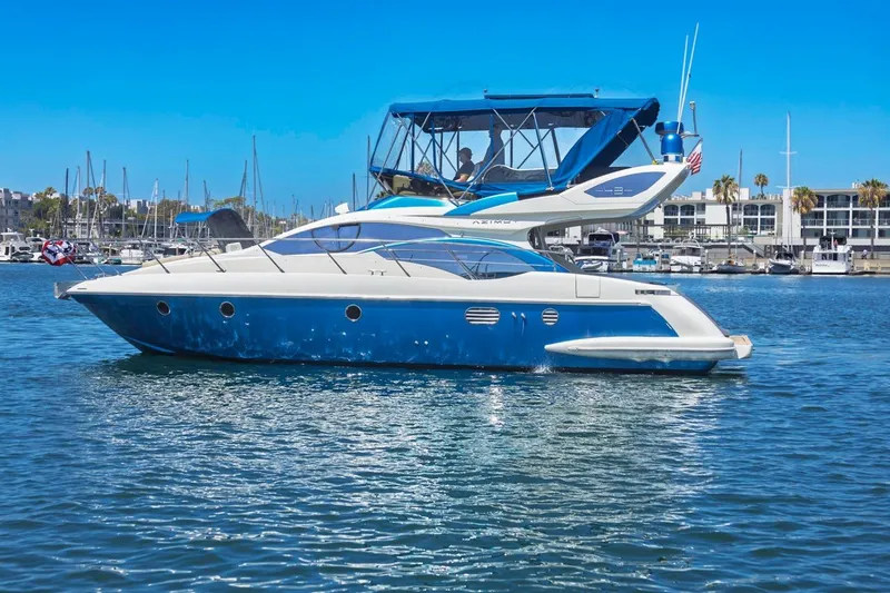The Image of 2006 Azimut 43 yacht on calm water, marina background, clear blue sky. - 0