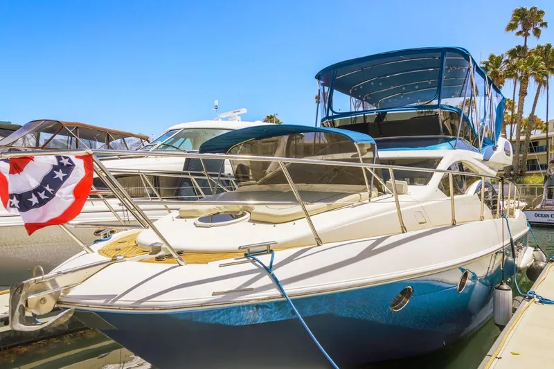 Slide: The Image of 2006 Azimut 43 yacht docked, featuring sleek design and blue canopy. - 8