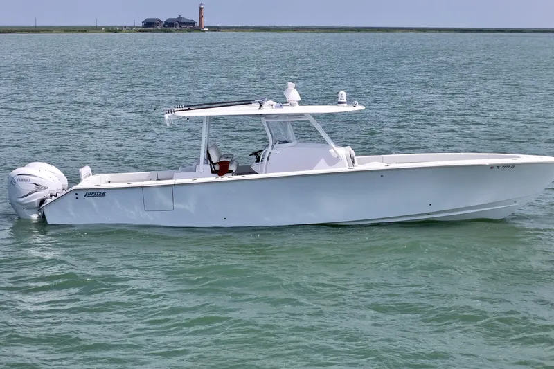 The Image of 2023 Jupiter 43 boat on calm water with distant lighthouse. - 0