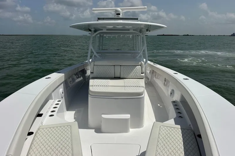 Slide: The Image of 2023 Jupiter 43 boat with cushioned seating on open water under cloudy sky. - 19