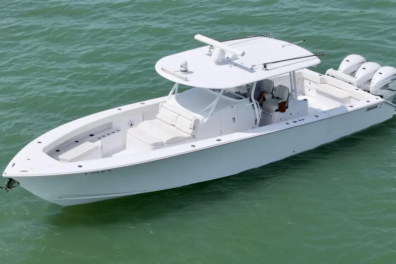 Slide: The Image of 2023 Jupiter 43 boat on calm green water, featuring sleek design and triple engines. - 2