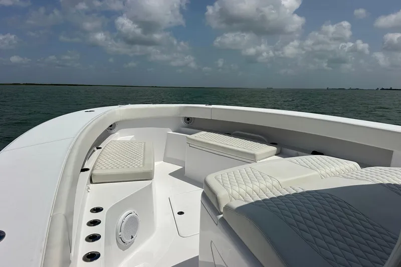Slide: The Image of Luxurious seating on a 2023 Jupiter 43 boat, cruising under cloudy skies. - 17