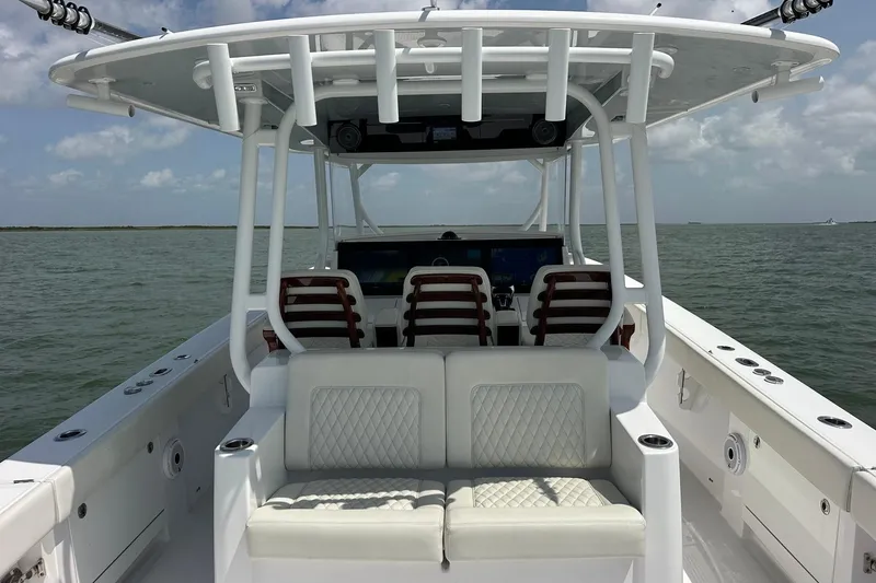 Slide: The Image of Luxury 2023 Jupiter 43 boat interior with cushioned seating on open water. - 11