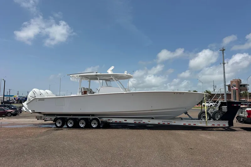 Slide: The Image of 2023 Jupiter 43 boat on trailer under clear blue sky. - 20