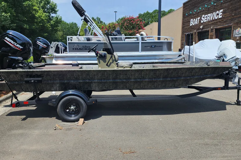 The Image of 2026 Tracker Grizzly 1860 CC boat on trailer, parked near boat service center. - 0
