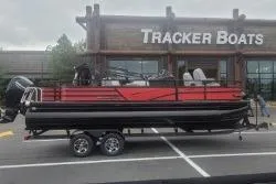 Slide: The Image of 2026 Ranger 220F pontoon boat on trailer at Tracker Boats dealership. - 57