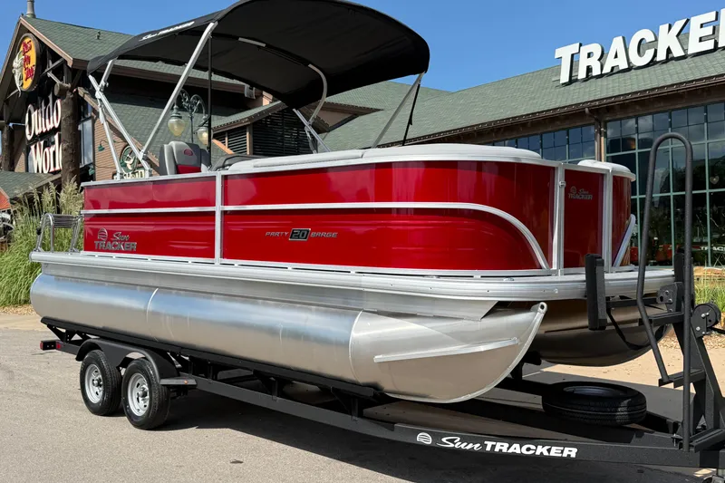 Slide: The Image of 2026 Sun Tracker Party Barge 20 DLX pontoon boat on trailer, outdoor store background. - 10