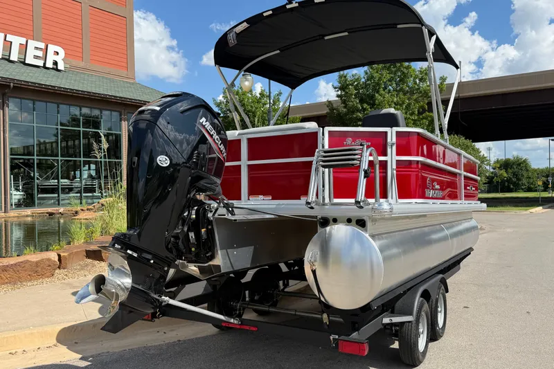 Slide: The Image of 2026 Sun Tracker Party Barge 20 DLX pontoon boat with Mercury engine, parked outdoors. - 11