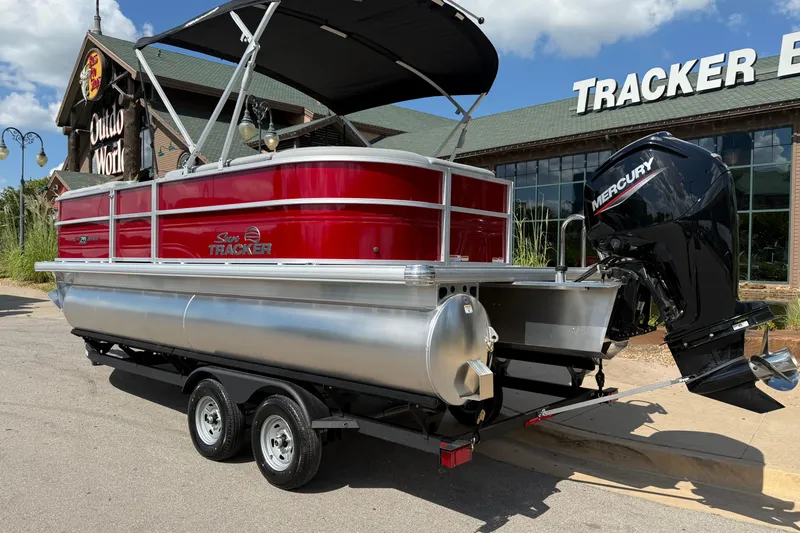 Slide: The Image of 2026 Sun Tracker Party Barge 20 DLX pontoon boat with Mercury engine, parked outdoors. - 3