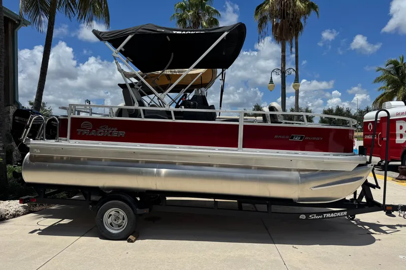 The Image of 2026 Sun Tracker Bass Buggy 18 DLX pontoon boat on trailer, parked outdoors. - 0
