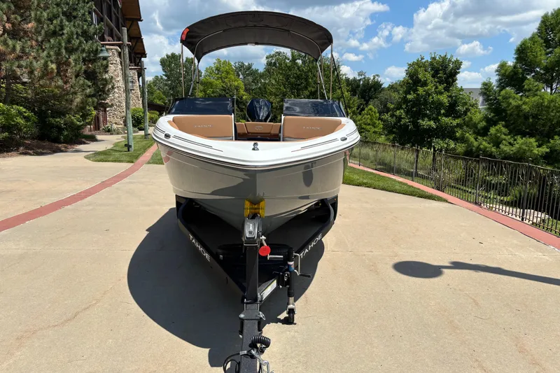 Slide: The Image of 2026 Tahoe 210 S boat on trailer, parked outdoors on sunny day. - 2
