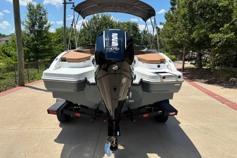 Slide: The Image of 2026 Tahoe 210 S boat with powerful outboard motor, parked on a sunny day. - 1