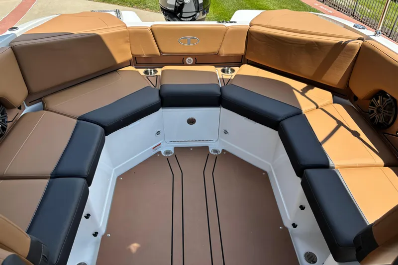 Slide: The Image of 2026 Tahoe 210 S boat interior with tan and black seating, cup holders, and speakers. - 6