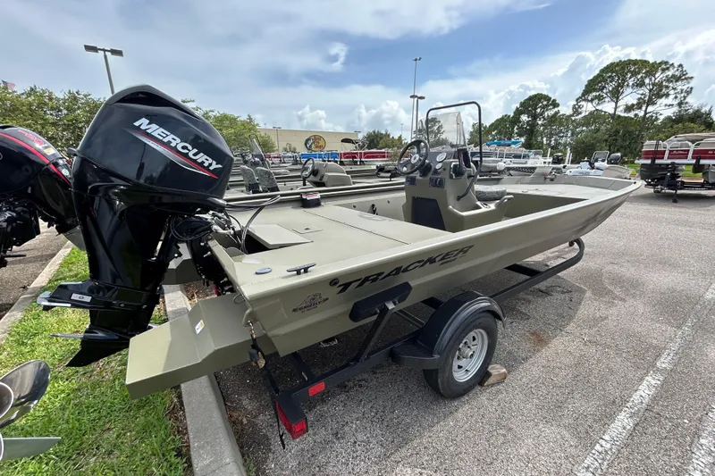 Slide: The Image of 2026 Tracker Grizzly 1860 CC boat with Mercury engine on trailer in parking lot. - 2