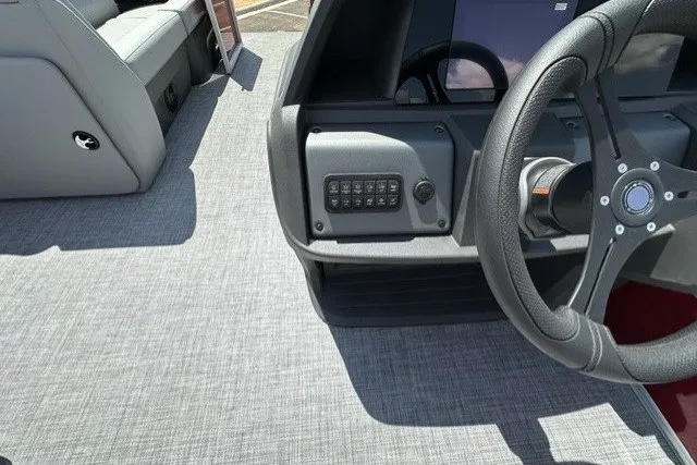 Slide: The Image of 2026 Sun Tracker Party Barge 20 DLX interior with steering wheel and control panel. - 18