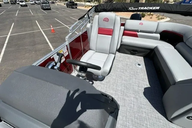 Slide: The Image of 2026 Sun Tracker Party Barge 20 DLX interior with gray and red seating in a parking lot. - 15