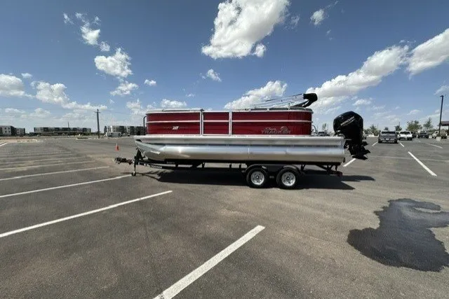 The Image of 2026 Sun Tracker Party Barge 20 DLX pontoon boat on trailer in parking lot. - 0