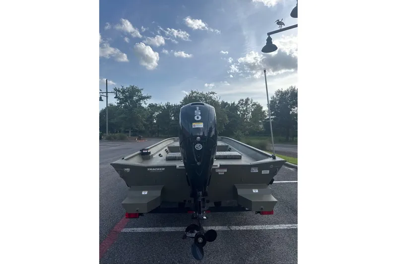Slide: The Image of 2026 Tracker Grizzly 2072 CC boat with outboard motor in parking lot under cloudy sky. - 3