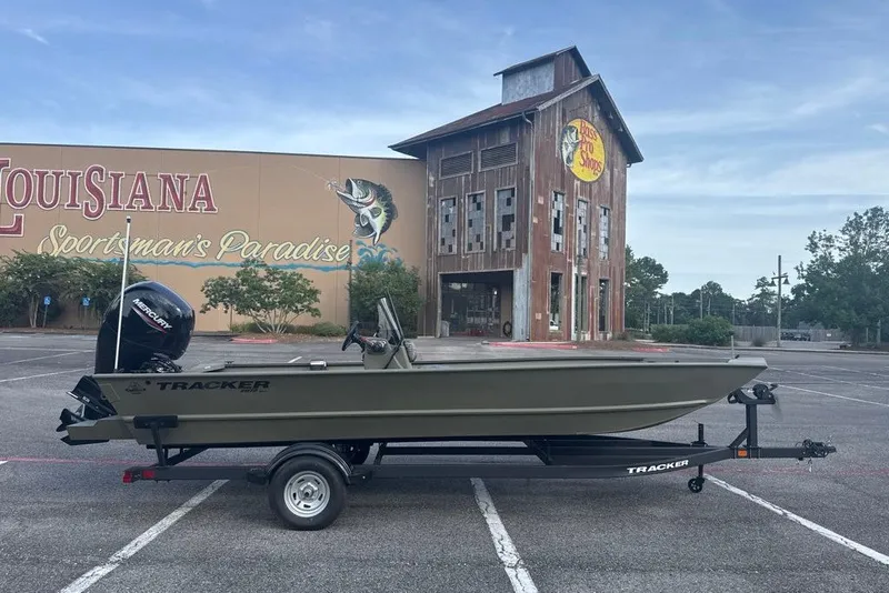 Slide: The Image of 2026 Tracker Grizzly 2072 CC boat on trailer, parked outside Bass Pro Shops. - 2