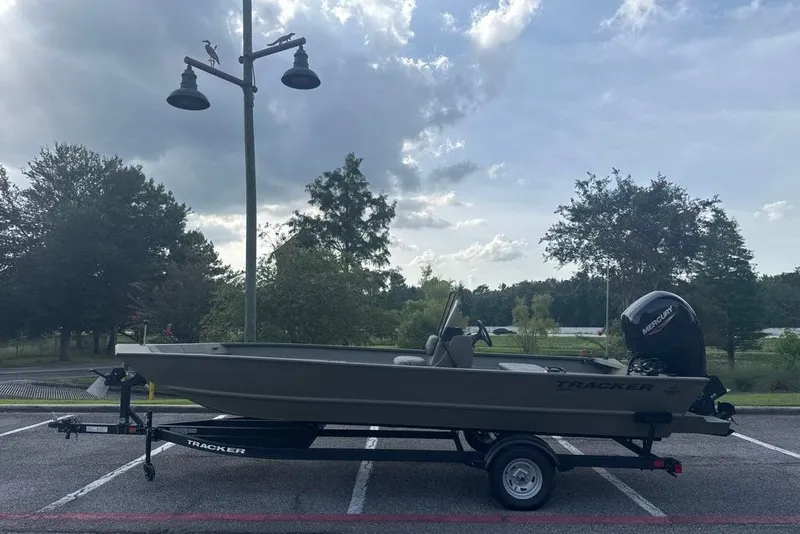 The Image of 2026 Tracker Grizzly 2072 CC boat on trailer in parking lot, cloudy sky background. - 0