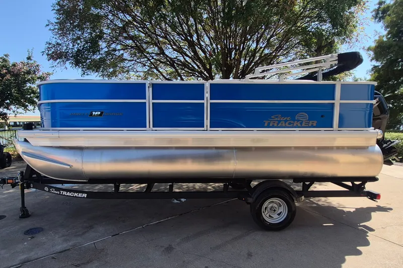 The Image of 2026 Sun Tracker Party Barge 18 DLX pontoon boat on trailer, parked outdoors. - 0