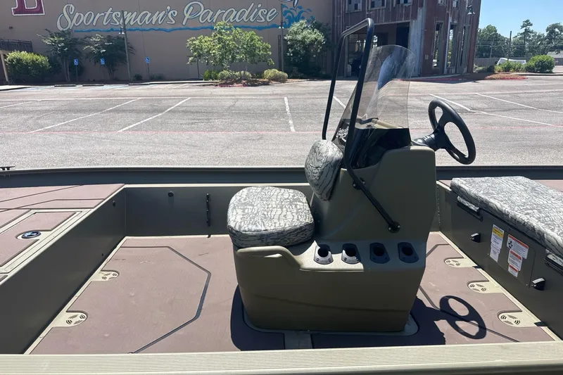 Slide: The Image of 2026 Tracker Grizzly 1860 CC boat interior with camouflage seating in parking lot. - 5