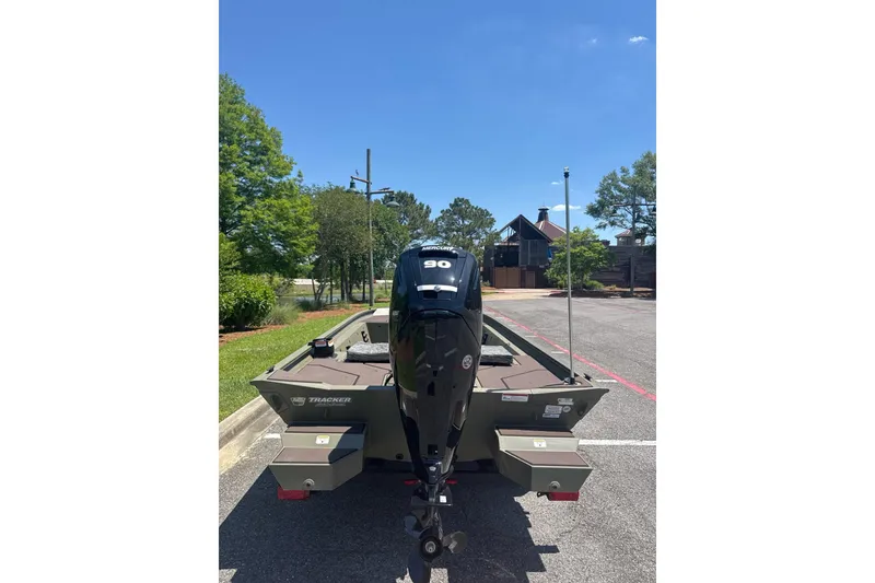 Slide: The Image of 2026 Tracker Grizzly 1860 CC boat with 90 HP motor in a parking lot. - 3