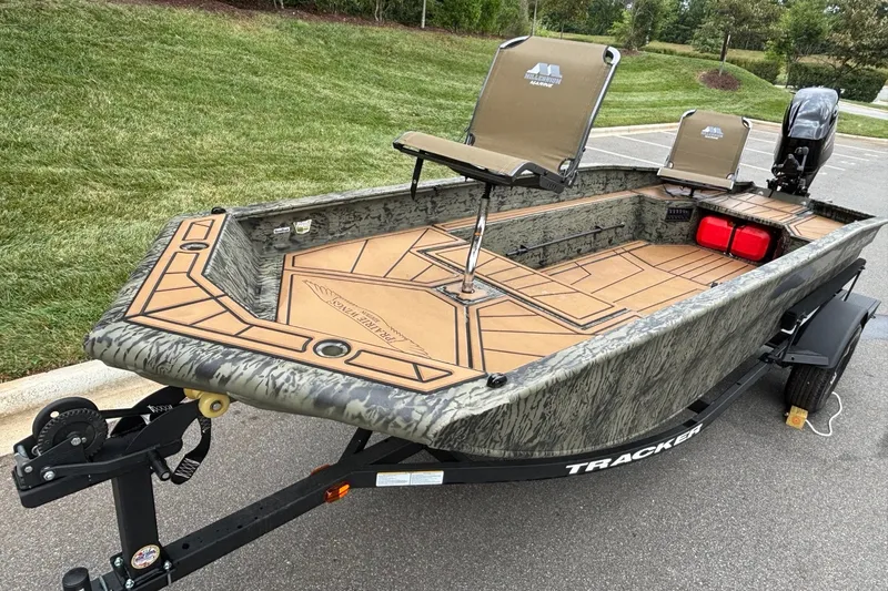 Slide: The Image of 2026 Tracker Grizzly 1650 T Prairie Wings Edition boat on trailer, camo design, outdoor setting. - 3