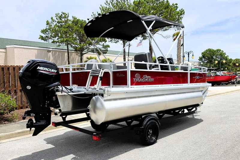 Slide: The Image of 2026 Sun Tracker Bass Buggy 18 DLX pontoon boat with Mercury engine on trailer. - 2