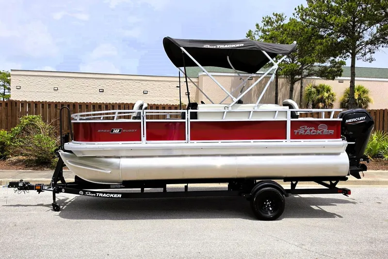 Slide: The Image of 2026 Sun Tracker Bass Buggy 18 DLX pontoon boat on trailer, parked outdoors. - 8