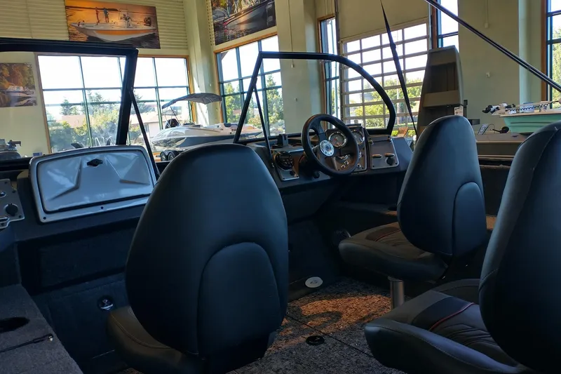 Slide: The Image of Interior of 2026 Tracker Pro Guide V-175 Combo boat in showroom setting. - 2
