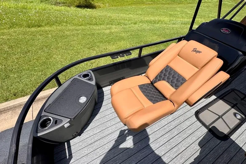 Slide: The Image of Luxurious seating on 2026 Ranger 223F boat with tan and black upholstery, set against green grass. - 9