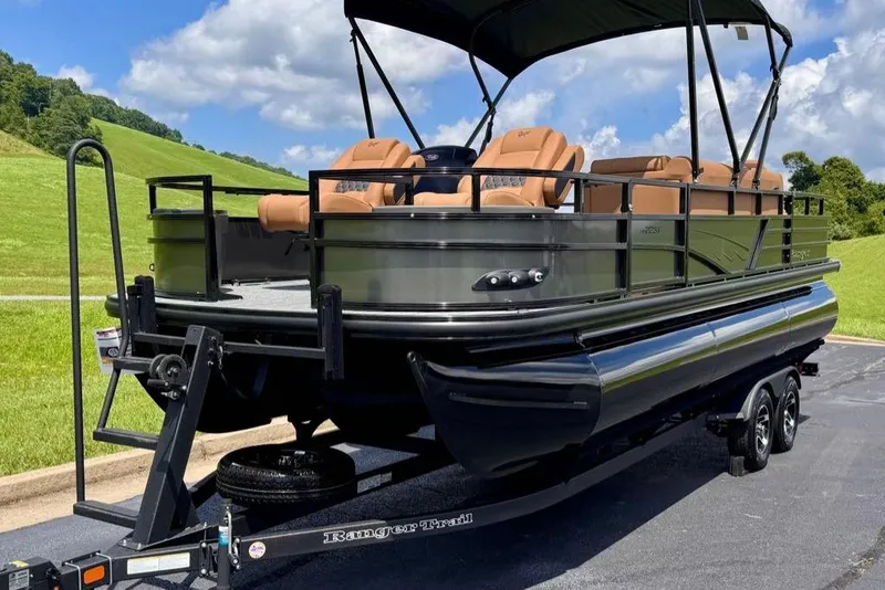 Slide: The Image of 2026 Ranger 223F pontoon boat on trailer, parked on a scenic road. - 3