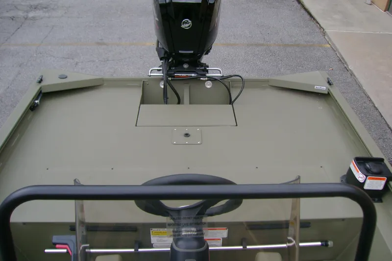 Slide: The Image of 2026 Tracker Grizzly 1860 CC boat interior with steering wheel and motor view. - 8