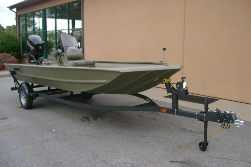 Slide: The Image of 2026 Tracker Grizzly 1860 CC boat on trailer, parked outdoors near a building. - 2