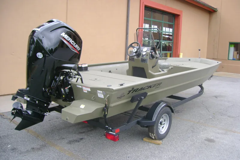 Slide: The Image of 2026 Tracker Grizzly 1860 CC boat with Mercury engine on trailer, parked outdoors. - 4