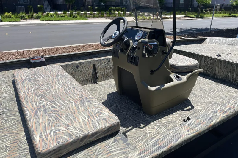 Slide: The Image of 2026 Tracker Grizzly 1860 CC boat interior with camouflage seating and steering console. - 6