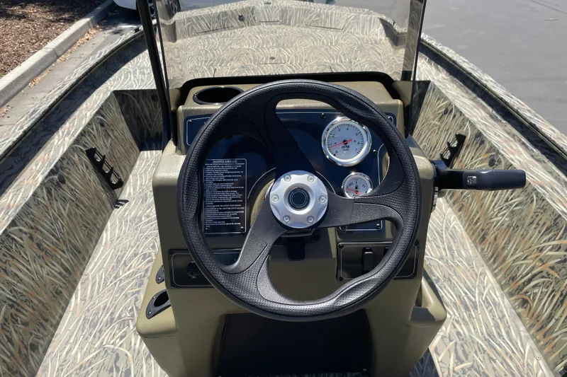 Slide: The Image of 2026 Tracker Grizzly 1860 CC boat dashboard with steering wheel and gauges. - 13
